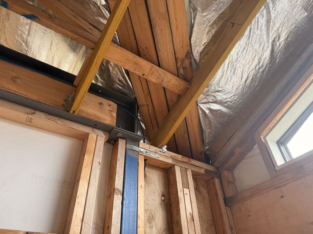 Roof framing, steelwork and the wall junction before internal linings.