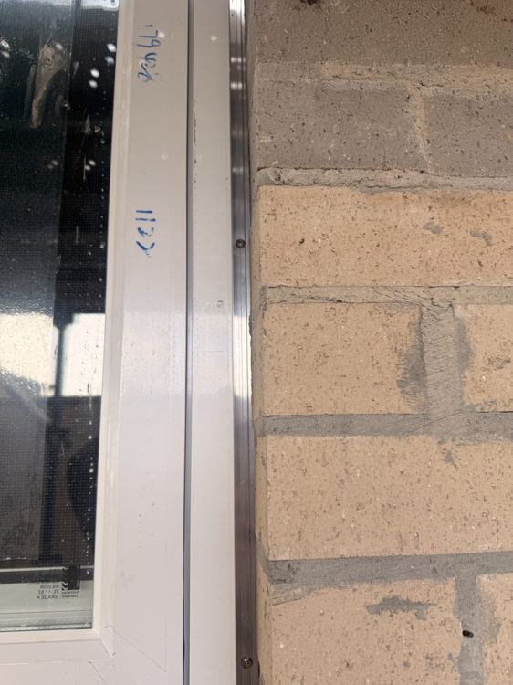 Close-up of a window frame and adjoining brickwork junction